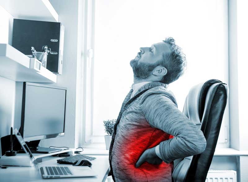 Man in office suffering from middle back pain