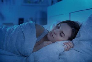 Woman peacefully sleeping in bed at night