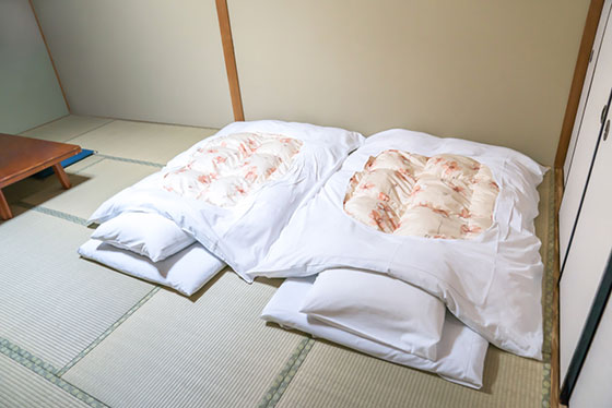 Futon a Japanese quilted mattress rolled out on the floor for use as a bed
